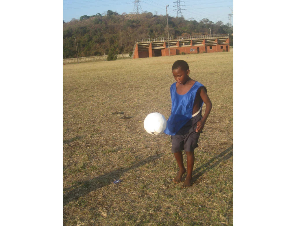 A young lad tests out the prototype sOccket power-generating soccer ball in a Durban, South Africa, trial of the device