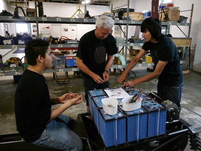 DeLaSalle High School student Ehiner Torrejas-Perez, mentor Brian Nackonechny, and Alta Vista High School student Emanuel Gutierrez install the resistors, in sequence, on the Li-ion battery pack