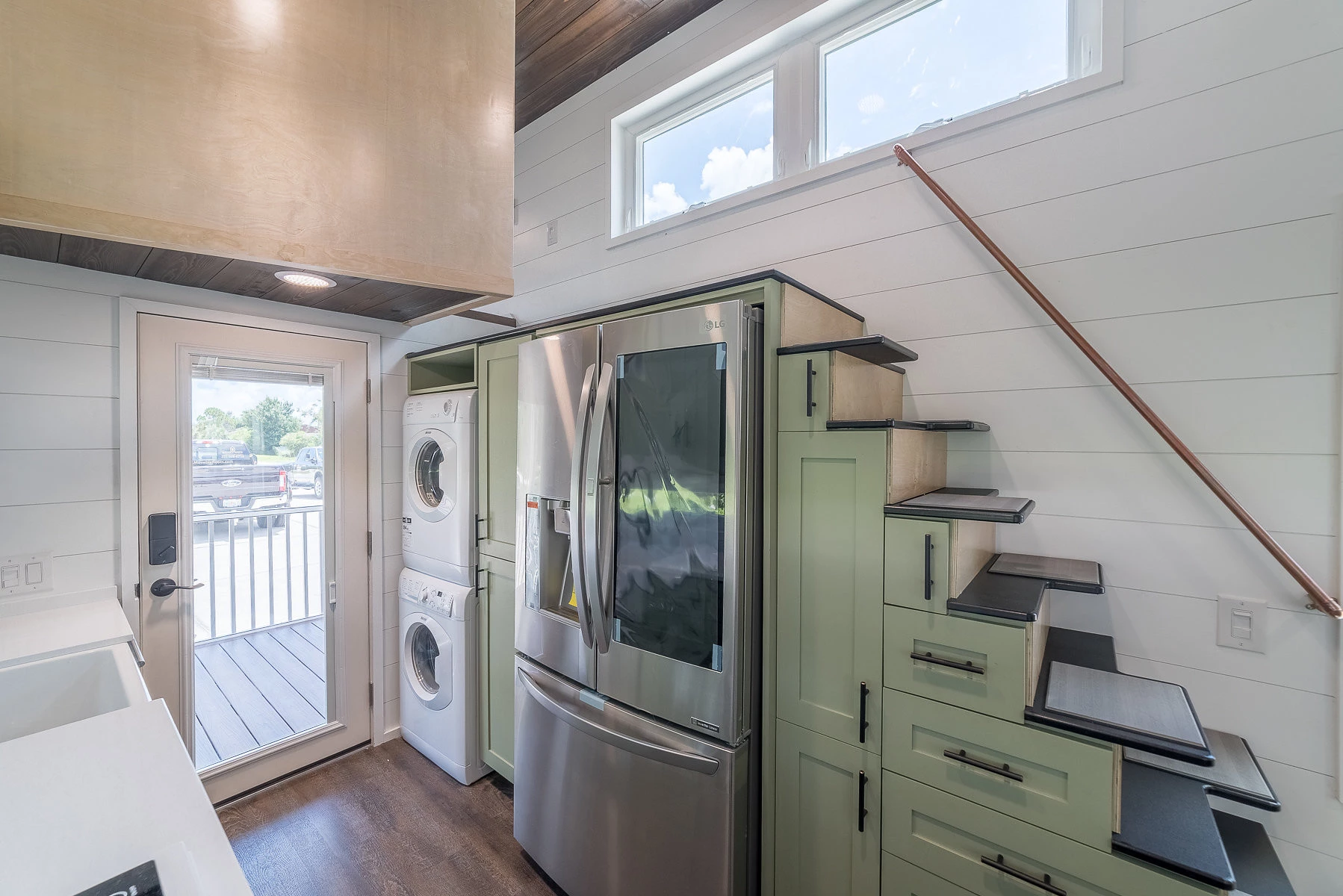 Movable Roots utilizes every space inch, with a stacking washer/dryer set and adding drawers and cabinets under the stairs. Speaking of, that's quite an interesting design on the staircase
