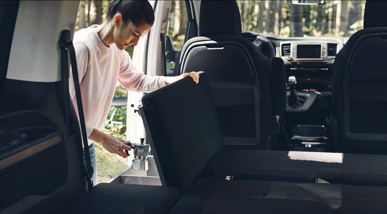 The module just inside the driver-side sliding door is a cushioned bench/bed extension and storage box