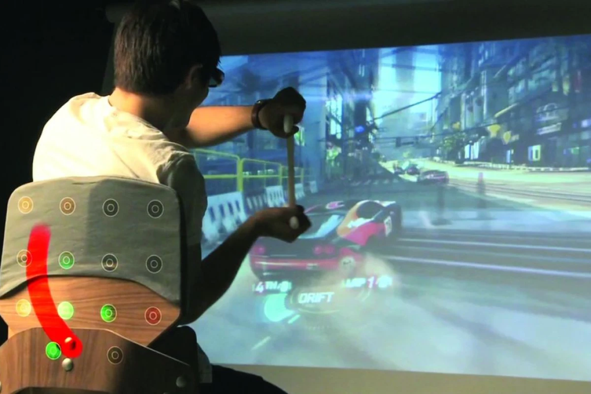 Surround Haptics enhances video game play by using an array of vibrating actuators in a chair to create the tactile illusion of continuous strokes on the player's back, illustrated in red (Image: Disney Research, Pittsburgh)