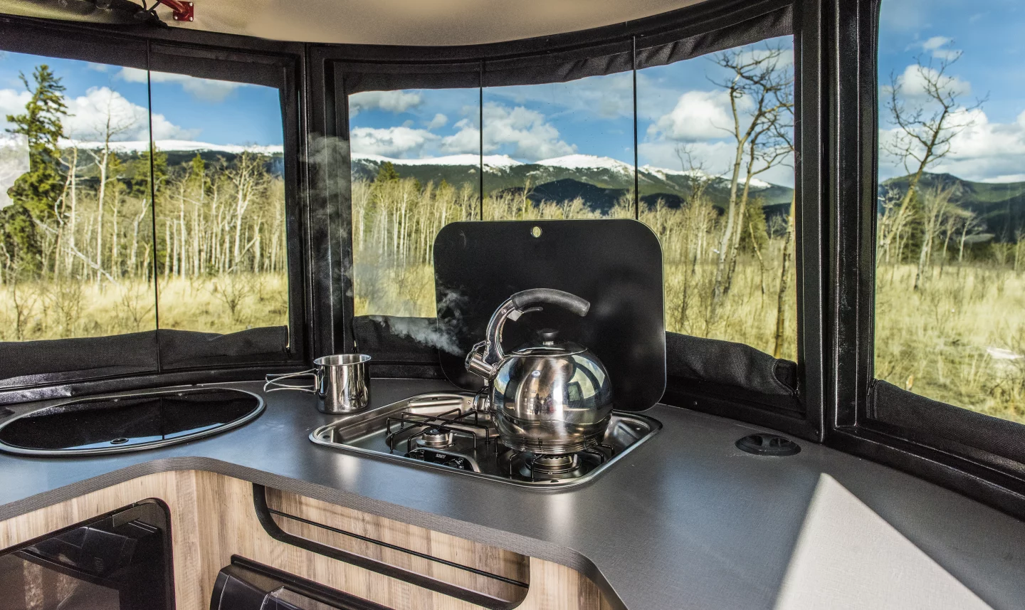 The front kitchen unit has a two-burner stove, sink, refrigerator and available microwave