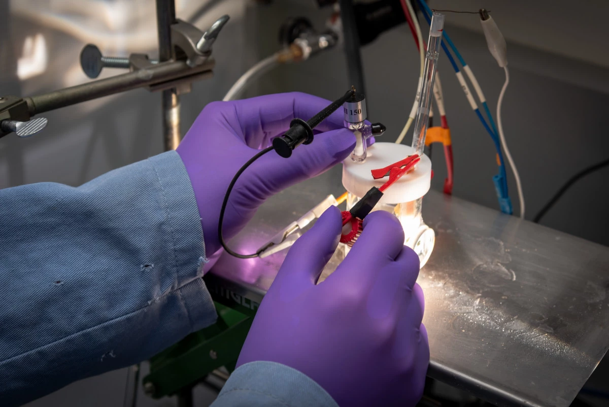 A scientists tinkers with a self-improving artificial photosynthesis device developed by US researchers