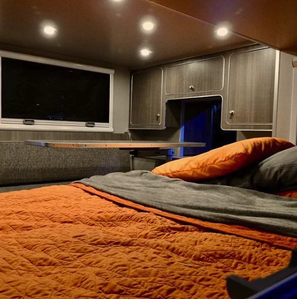 Many small trailers include a cabin occupied completely by the mattress, but OverKill makes room for a dinette by building a sliding side expansion