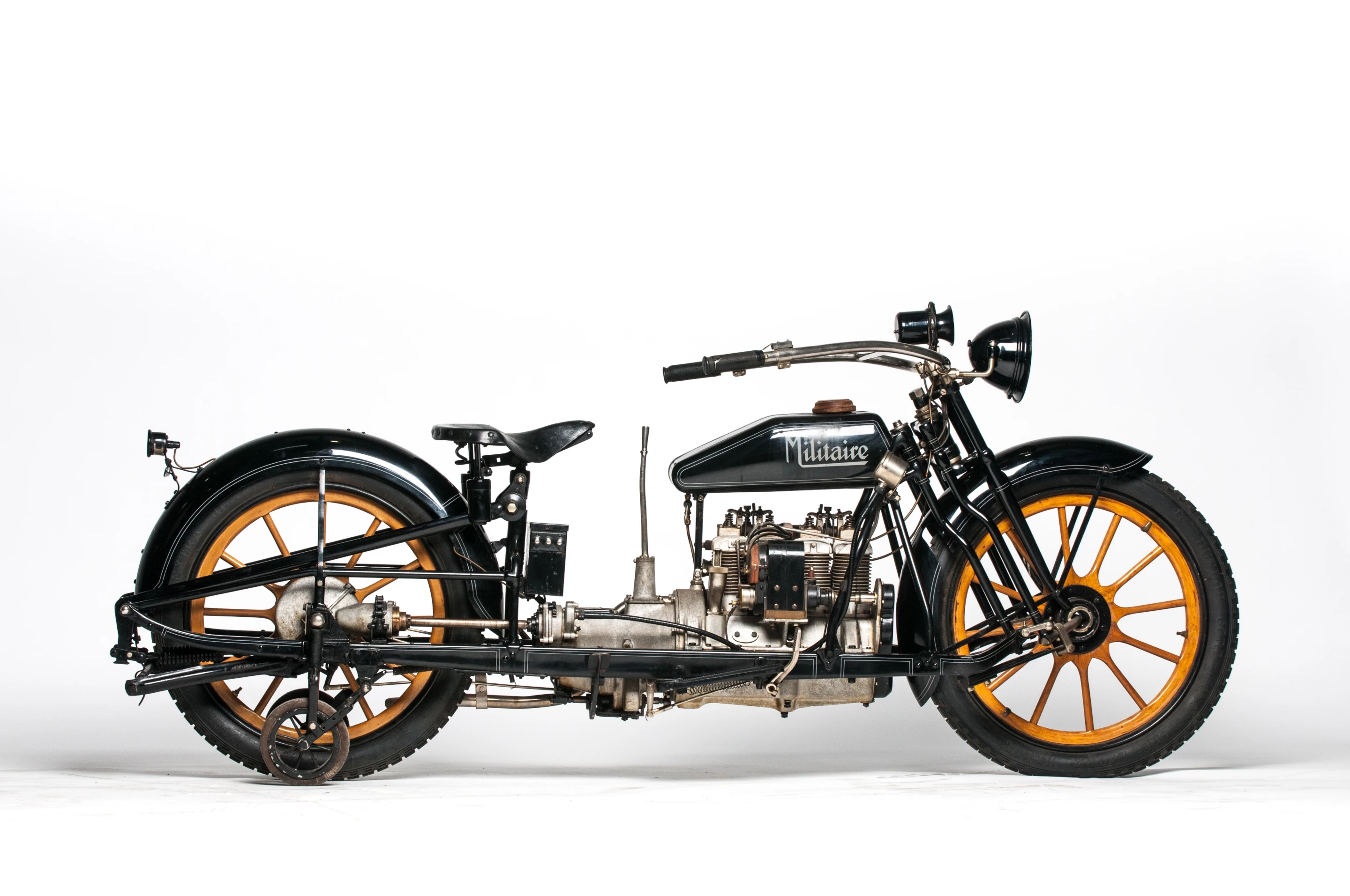 This 1915 Militaire Model 2 is a fascinating and unconventional four-cylinder motorcycle with an equally fascinating history as it was developed through several manufacturers. Now very collectible and extremely rare, the "two-wheeled car" features outrigger wheels which are operated by lever for low speeds, center-hub steering and wooden wheels.