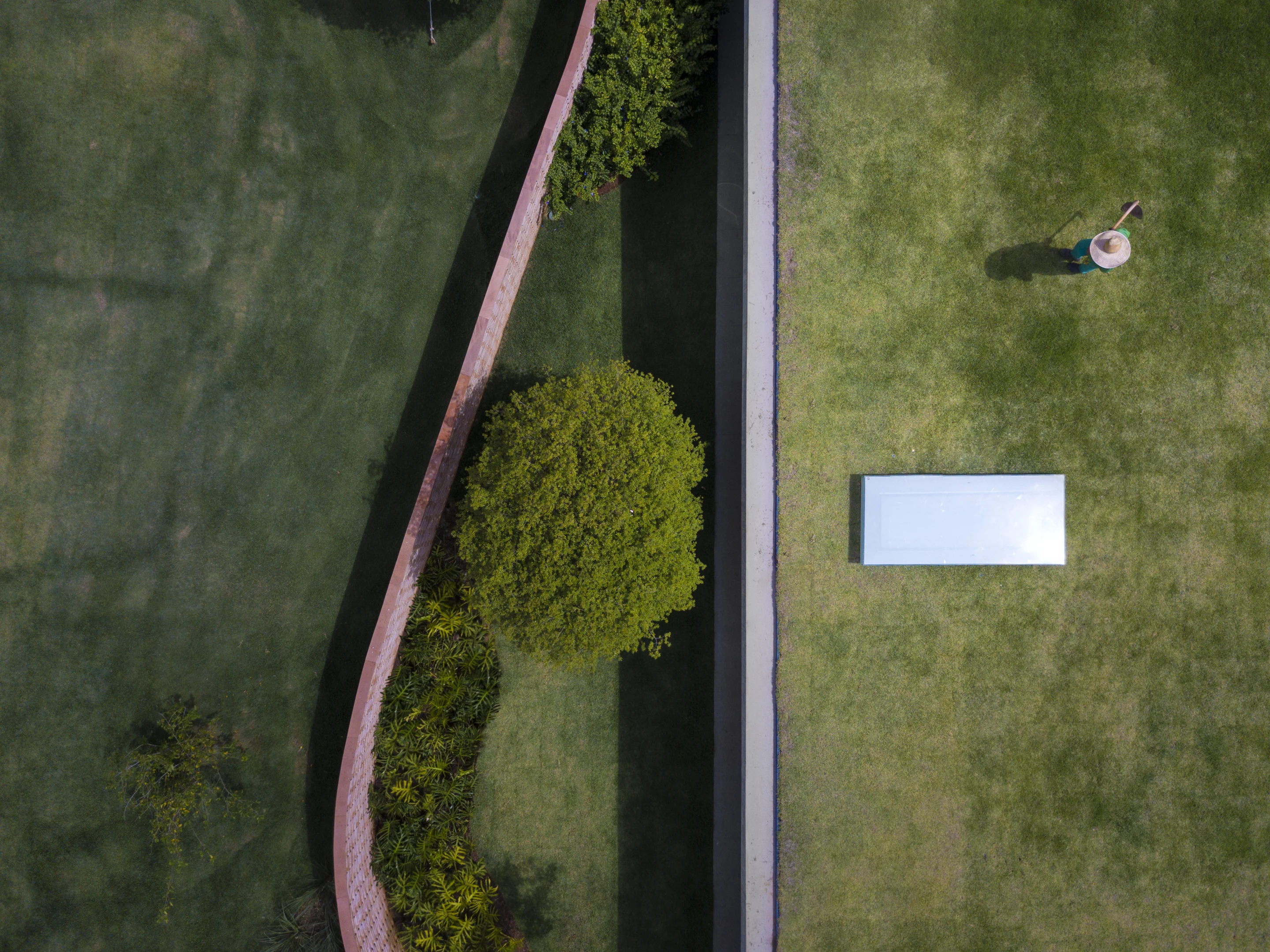 Planar House is partially enclosed by a large curving brick wall