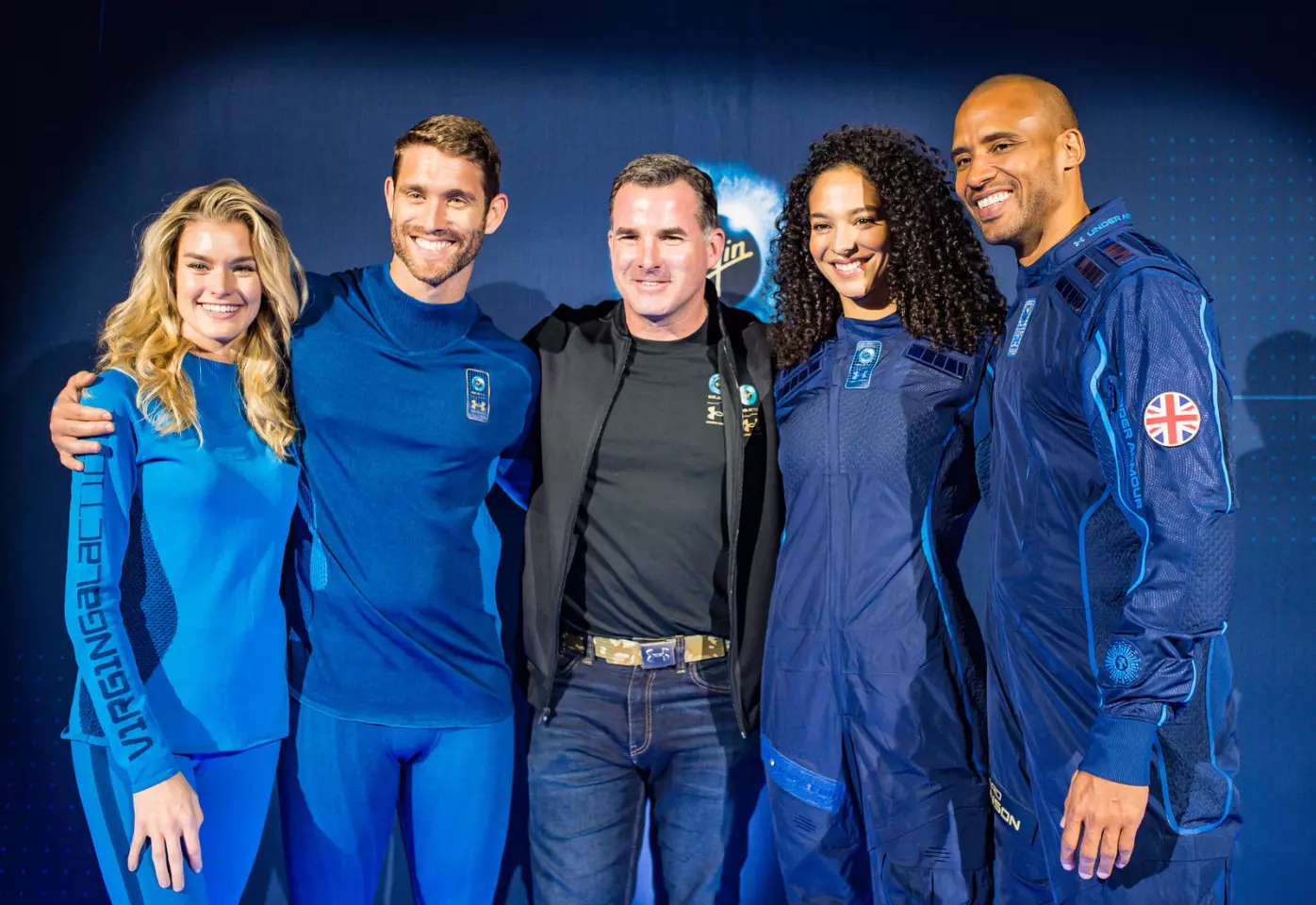 Under Armour Founder Kevin Plank stand with models wearing the UA-designed base layer and spacesuit