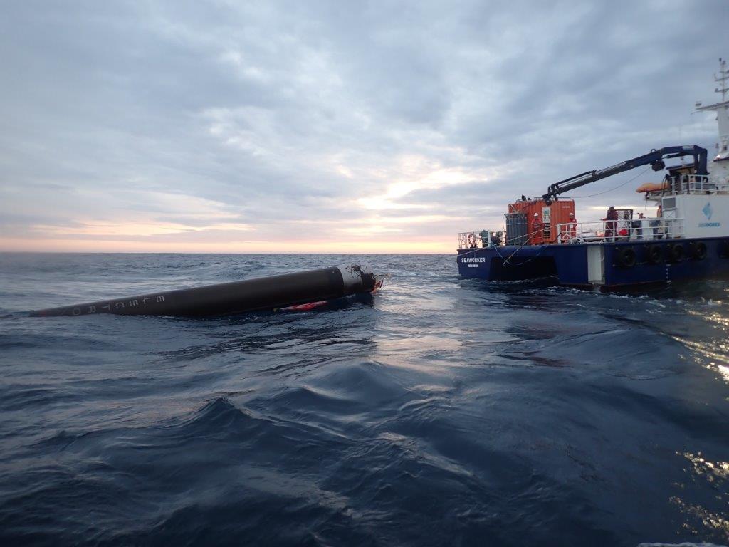 Rocket Lab's Electron first stage rests in the water following a recovery mission in 2020