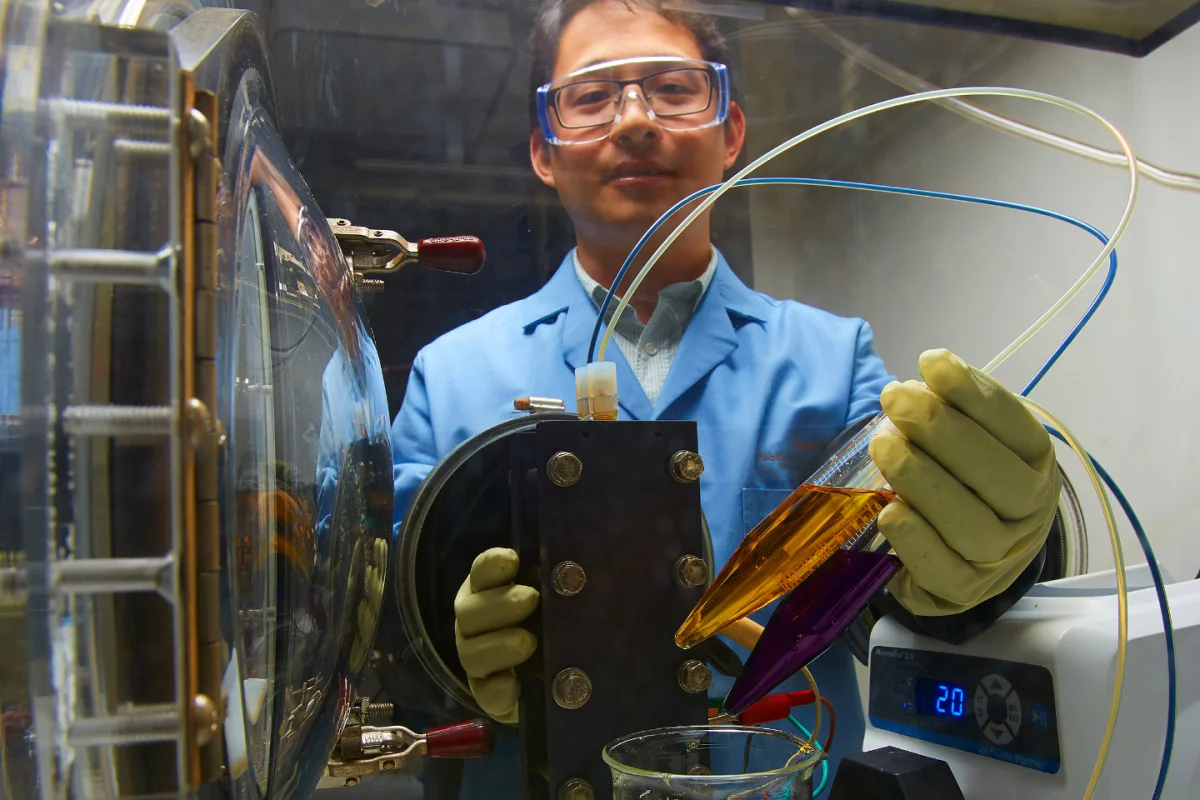 A new flow battery technology is expected to cost substantially less and be better for the environment thanks to its organic water-based electrolytes, as seen here in a small demonstration by PNNL researcher Xiaoliang Wei