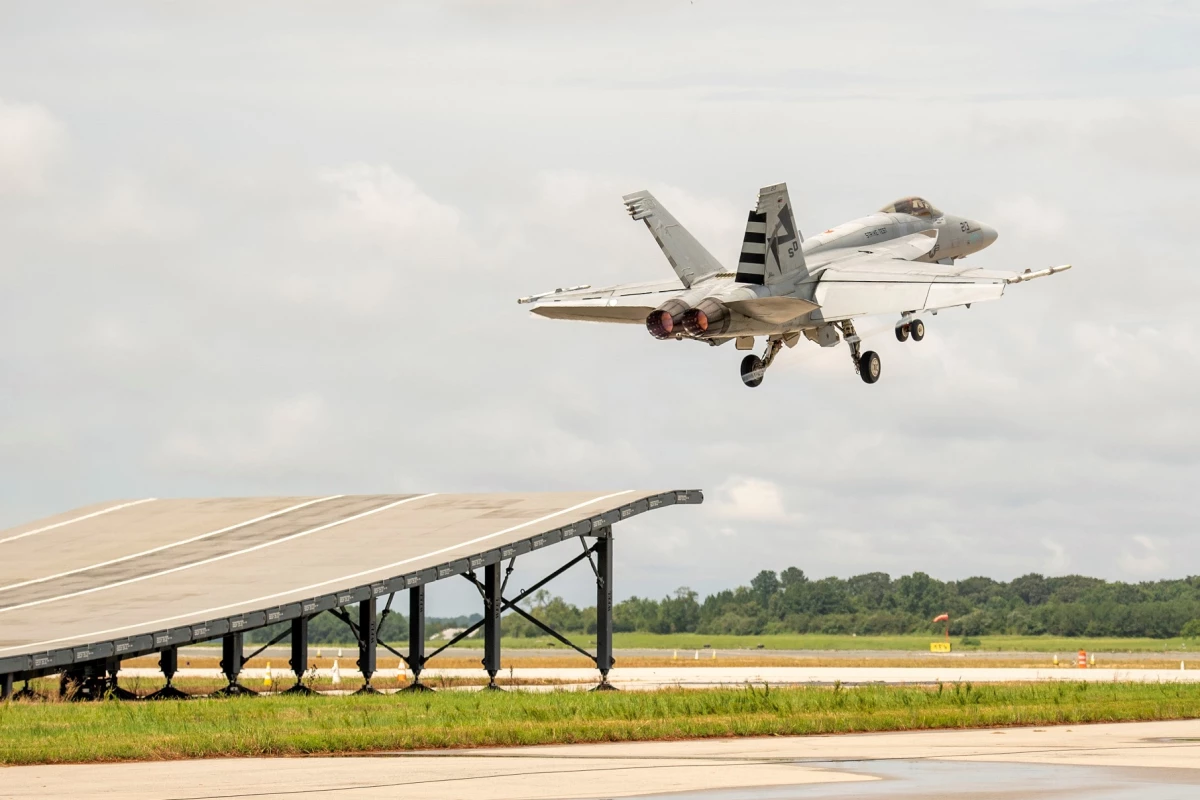 A F/A-18 Super Hornet taking off from ski-jump ramp for the first time