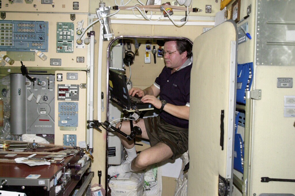 Cosmonaut Nikolai M. Budarin, working in his sleep station in the Zvezda Service Module aboard the ISS (Photo: NASA)