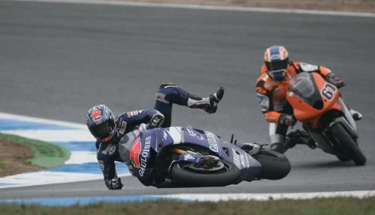 Colin Edwards slips off at low speed. Edwards was able to remount and bring home sixth place. That's Shakey Byrne on the KTM-engined Team Roberts Proton in the background.