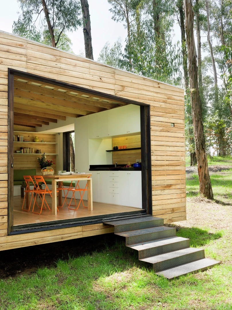 The main area of the house features a large floor to ceiling glass sliding wall, which opens out completely, extending the living area into the natural outdoor landscape