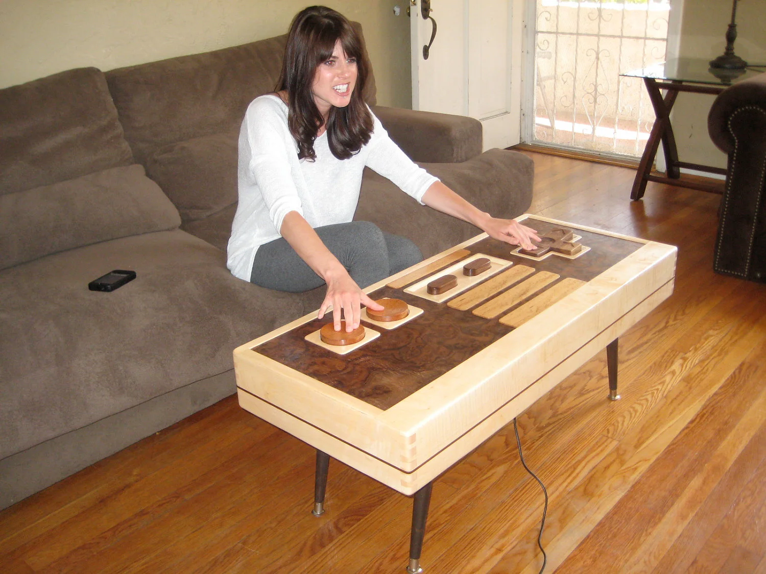 Charles Lushear has designed and built a coffee table that resembles a Nintendo Entertainment System controller, with buttons and a joypad that can actually control onscreen gaming action