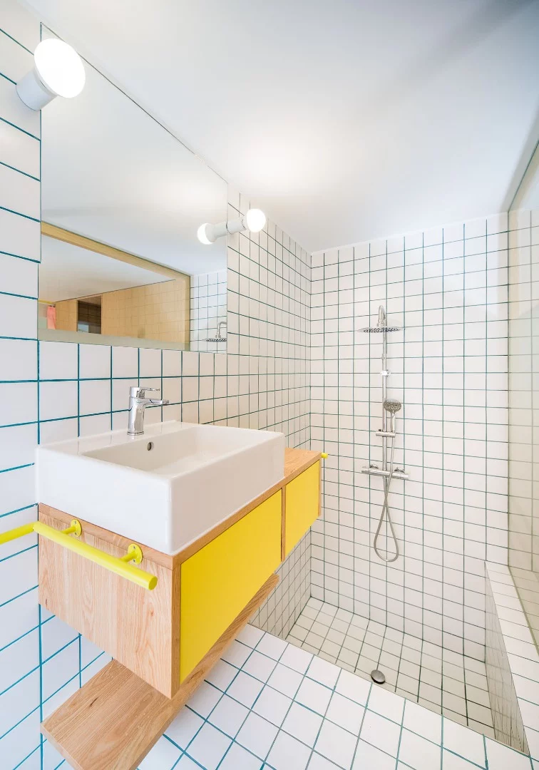 The bathroom features a shower over a bath tub, toilet, basin and mirror and storage cupboard