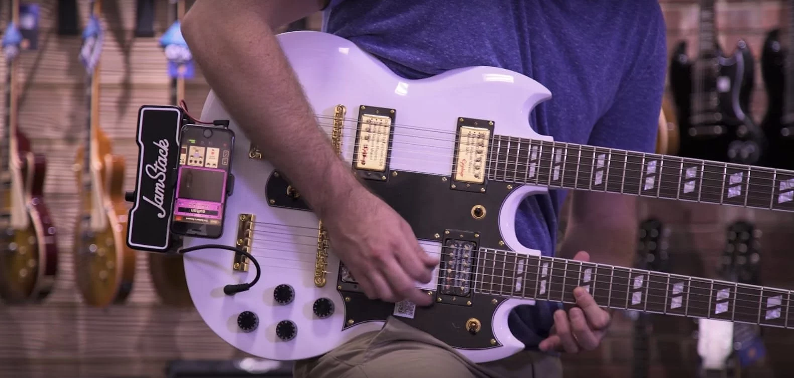 The JamStack clipped onto the strap peg of a doubleneck SG and running effects supplied by a docked smartphone