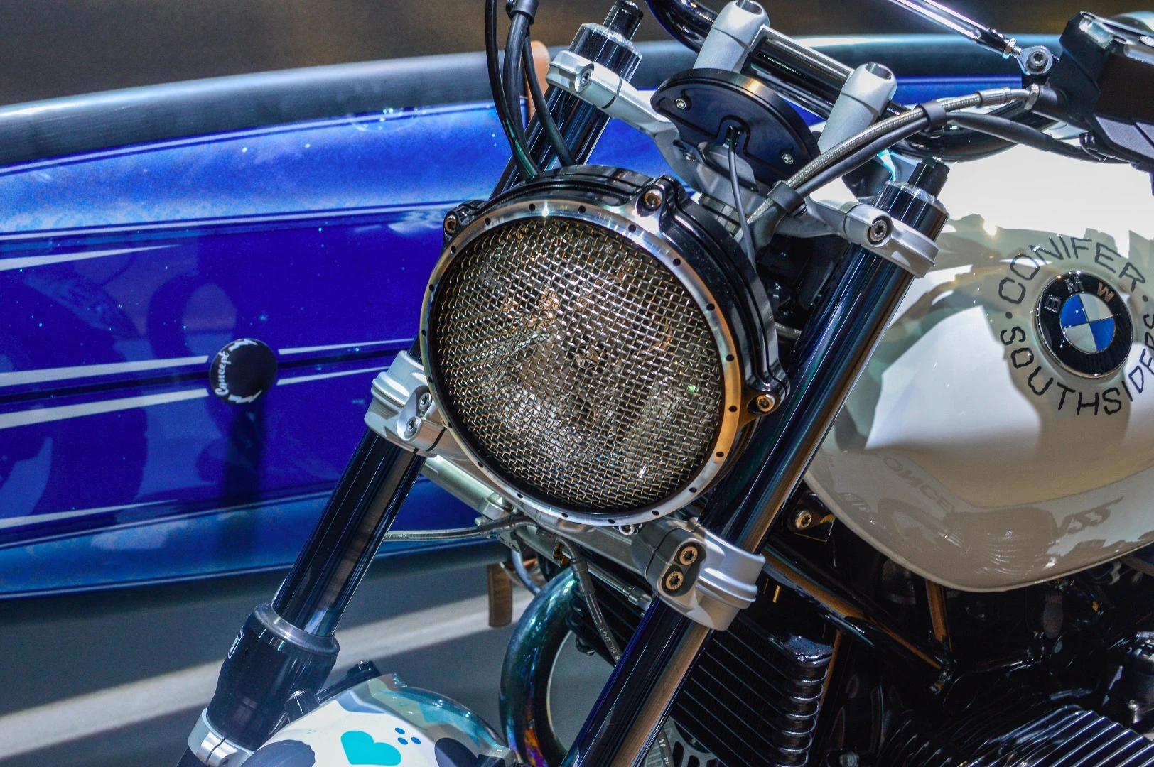 A metal mesh protects the headlight's glass from loose branches of flying debris when riding off-road