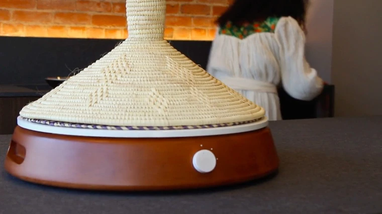 The wooden-bodied device incorporates an induction coil, which quickly and efficiently delivers heat through a ceramic base to a removable iron plate