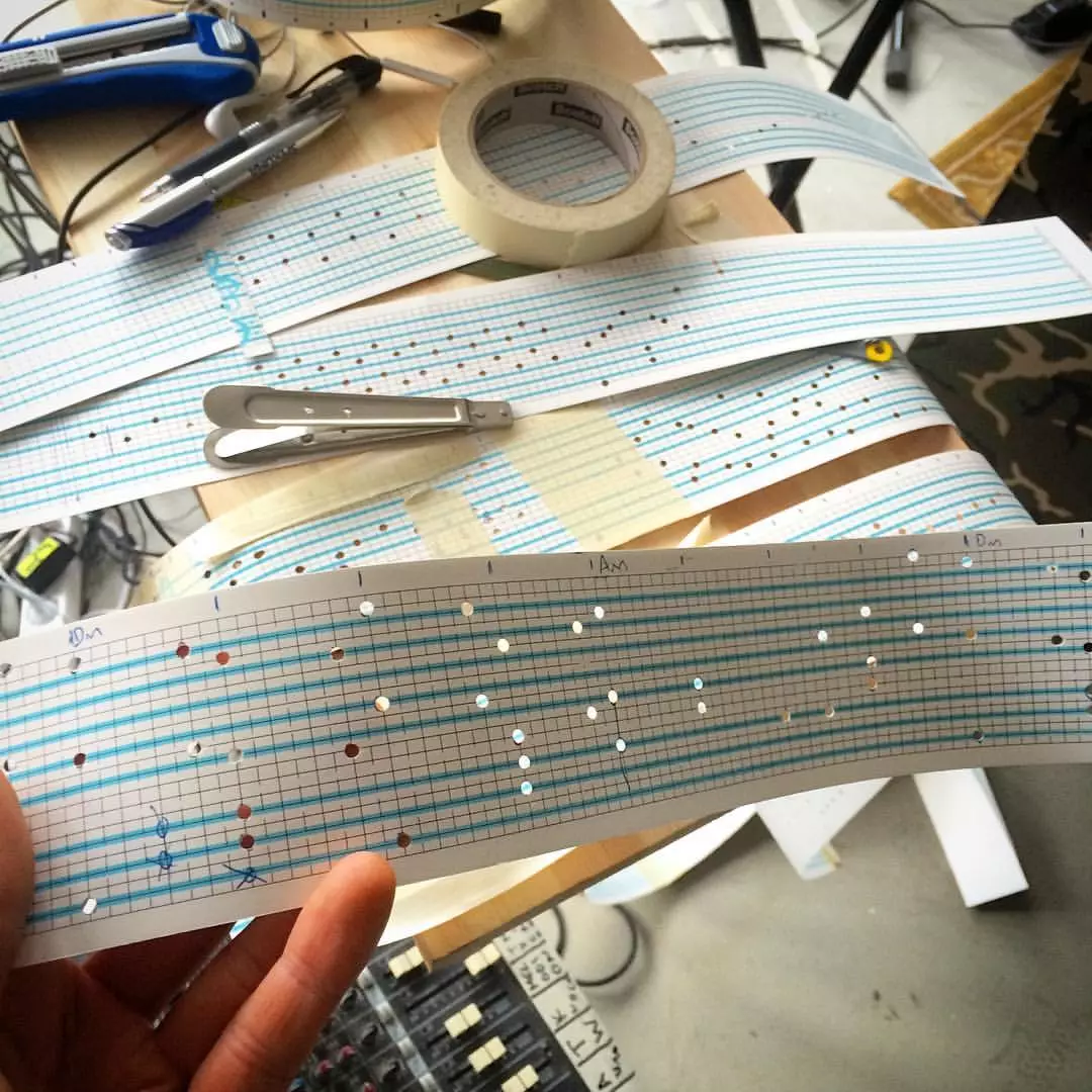 The melody to be played is punched into programming paper by hand