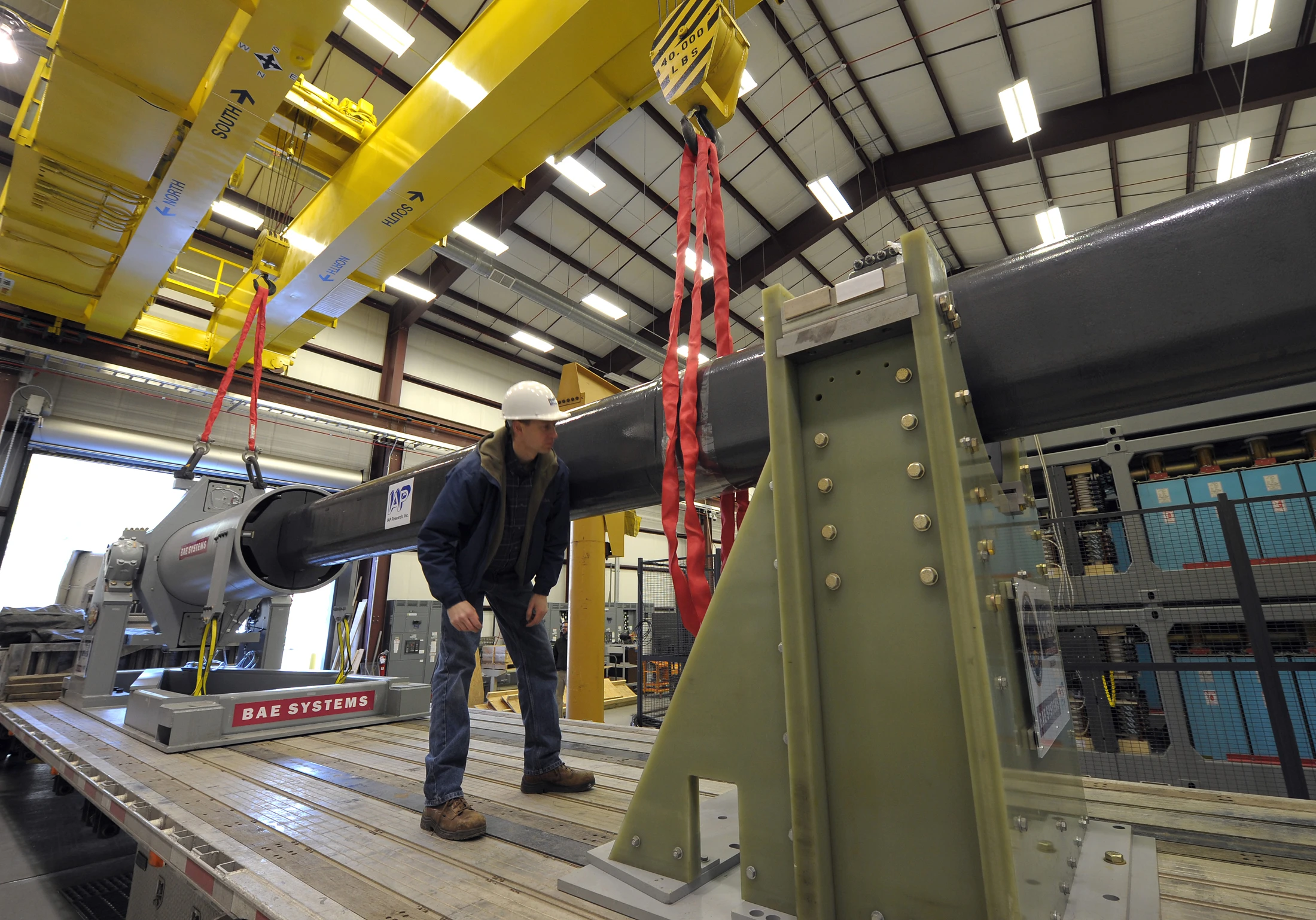 Tony Deschenes, an engineer with BAE Systems, makes final checks prior to maneuvering the 32-MJ version of the Office of Naval Research-funded Electromagnetic Railgun (EMRG) prototype into place (Photo: U.S. Navy photo by John F. Williams)