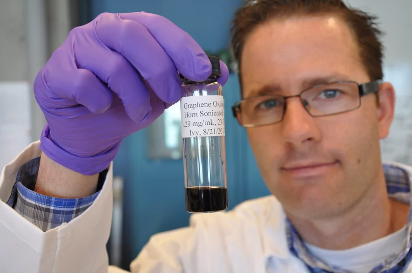 Jacob D Lanphere, a Ph.D. student at UC Riverside, holds a sample of graphene oxide