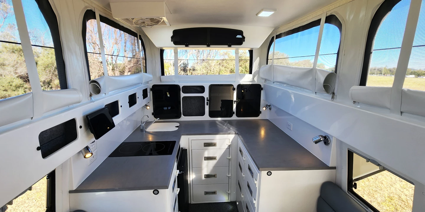 The U-shaped kitchen provides serious countertop space, along with an induction cooktop, sink, microwave and fridge