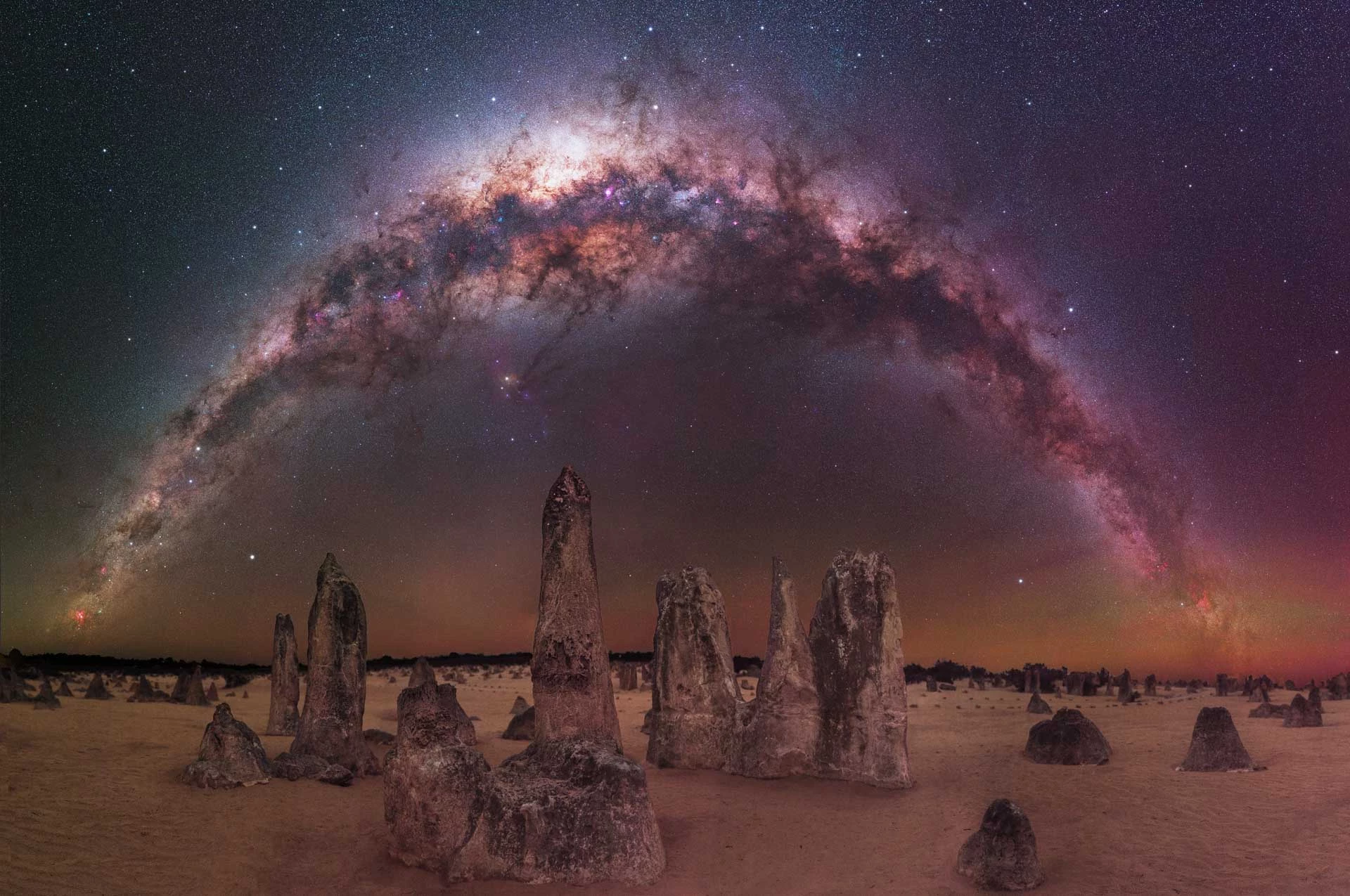 The Milky Way Arching Over The Pinnacles Desert. Limestone monoliths stretch into the heavens from the outback of Western Australia