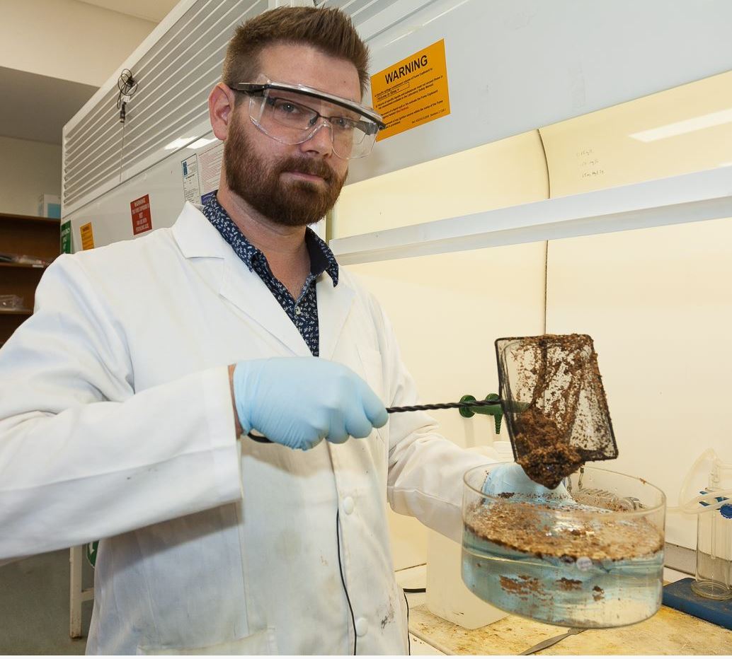 Dr Chalker demonstrates the polymer sorbent in the Chalker Lab at Flinders University