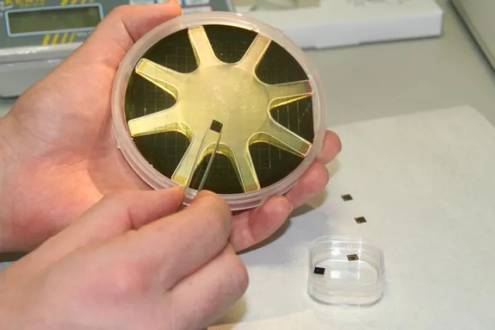 One of the DNA-reading chips, displayed against the prototype device (Photo: Imperial College London)