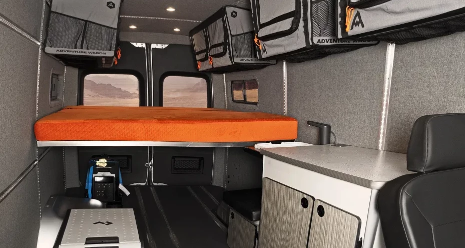 The Winnebago + Adventure Wagon camper van's high bed mounts over top the EcoFlow power station and cargo