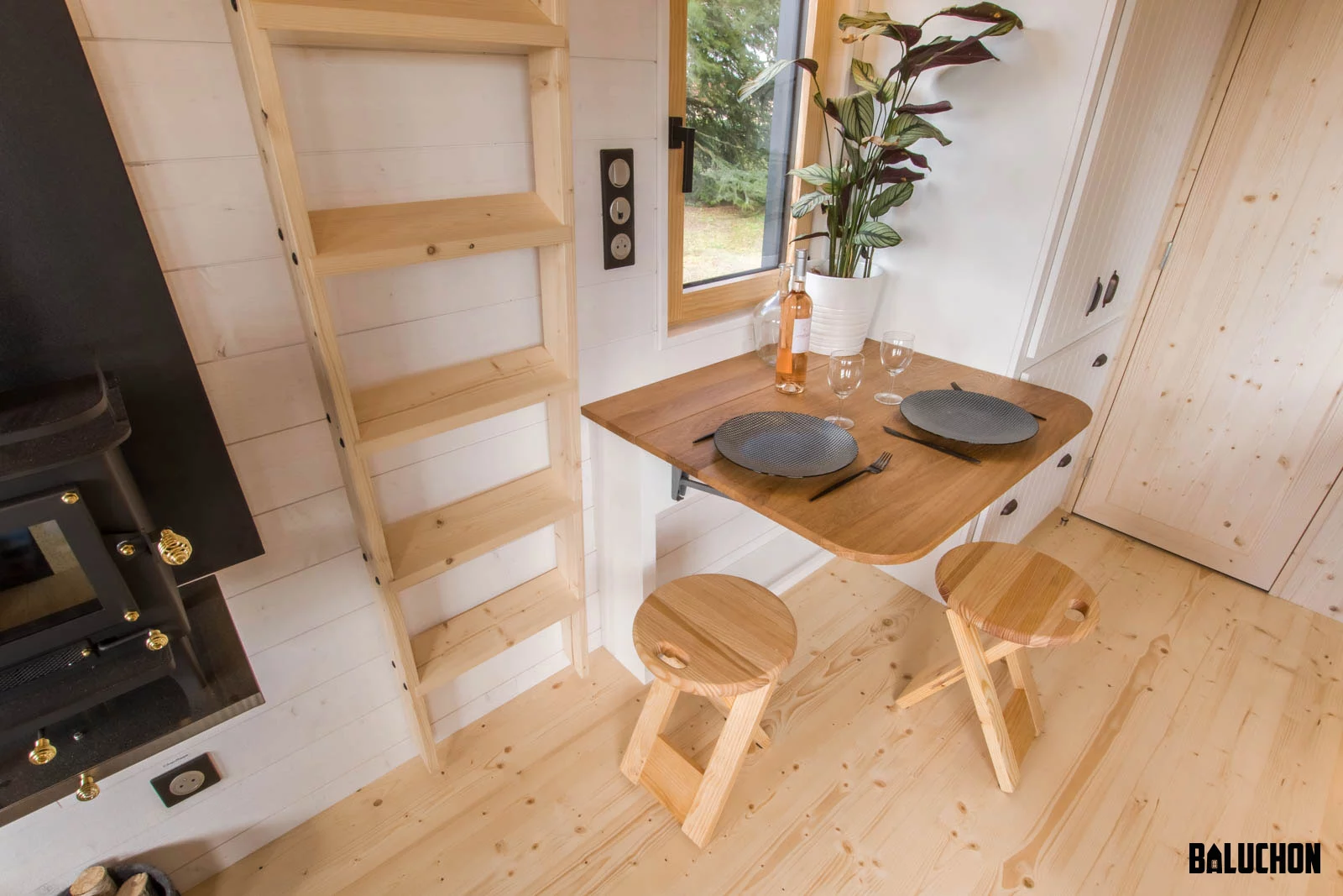 The Miss Twain Tiny House's kitchen includes a drop-down dining table for two