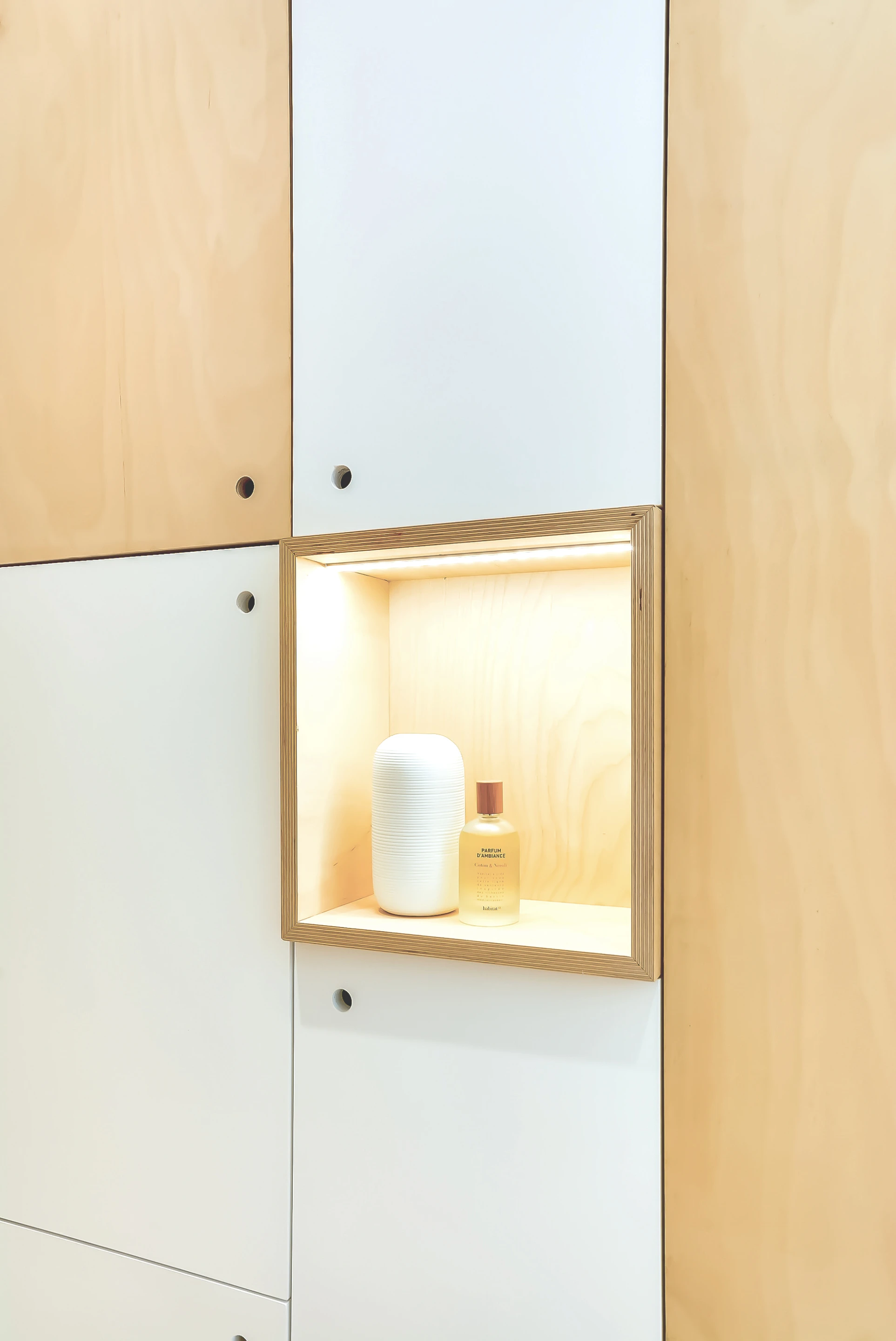 An entire wall of the apartment features a large cabinet unit which opens at points to reveal a hidden television, wine rack, refrigerator, and clothing rails (Photo: Meero)
