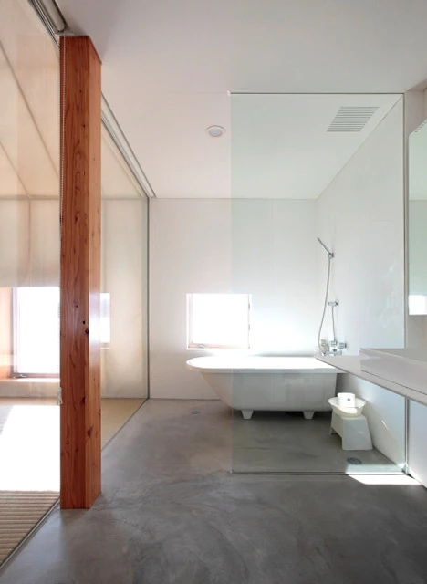 The bathroom is placed within a glass area in the corner of the building