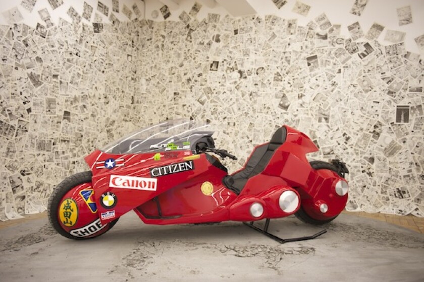 Exhibition visitors can have their picture taken sitting on the bike among a post-apocalyptic backdrop