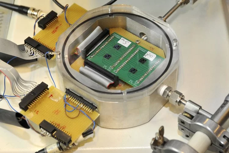 Four chips are placed in a vacuum container and the tones produced are sent to be amplified thousands of times