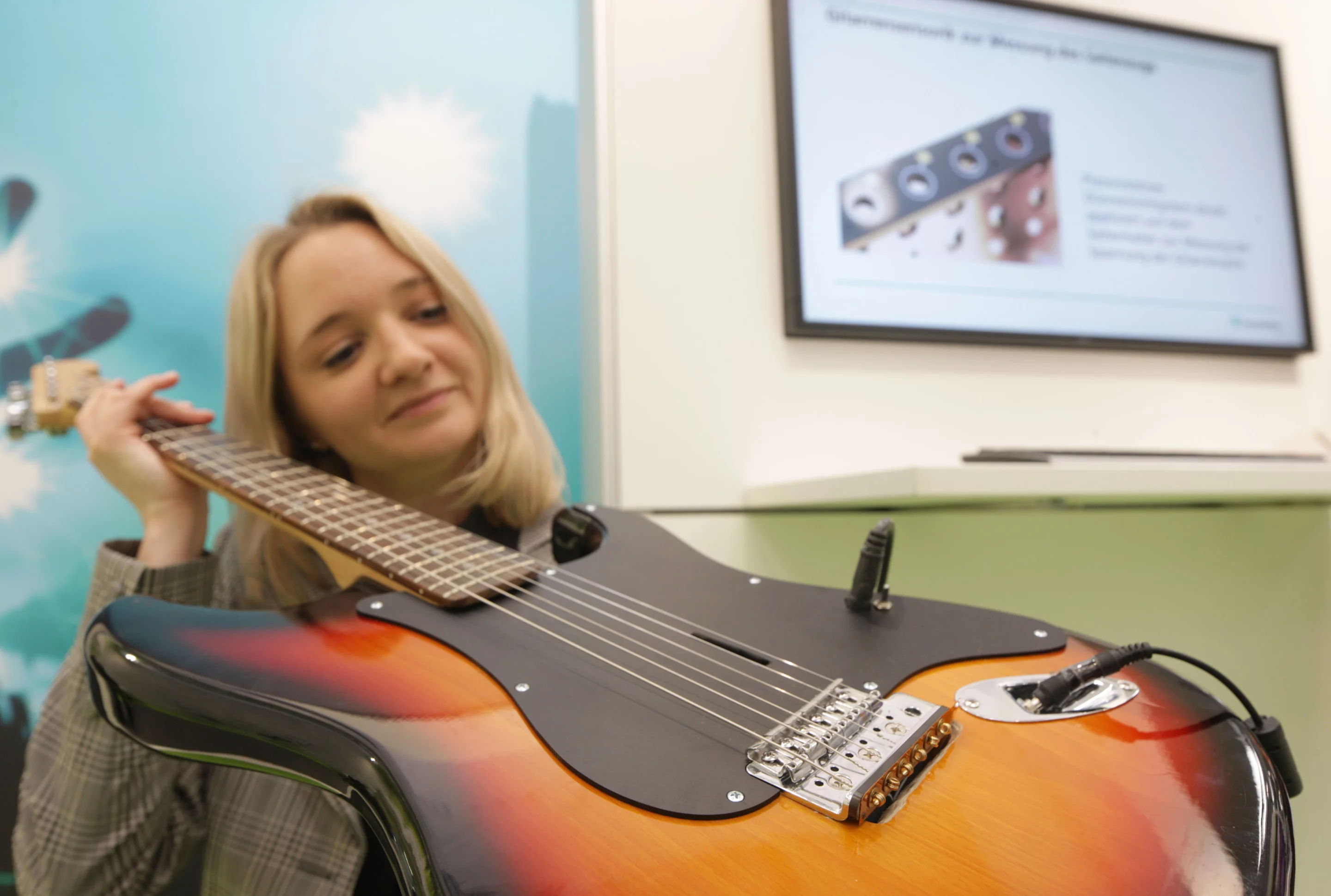 Dipl.-Ing. Saskia Nina Biehl shows a guitar fitted with the new sensing technology (Photo: Fraunhofer, photographer: Kurt Fuchs)