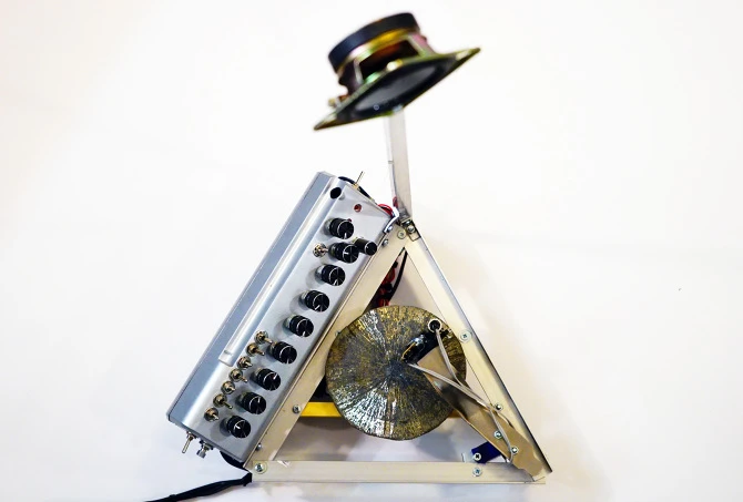 The control board runs down one edge of the triangular base