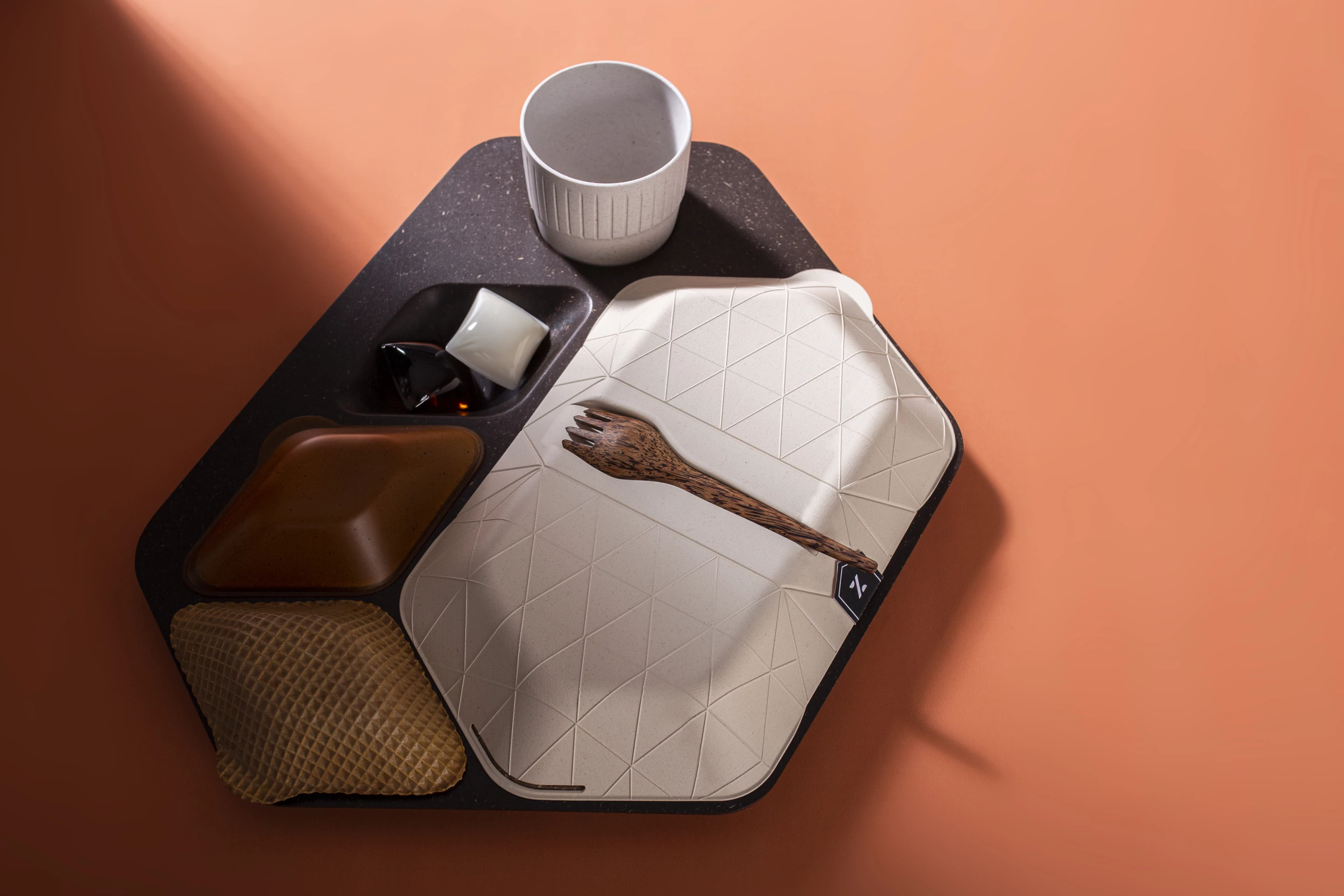 The in-flight tray concept includes a reusable spork made from coconut wood and reusable cup with an exterior made from rice husk, PLA binder and algae lining