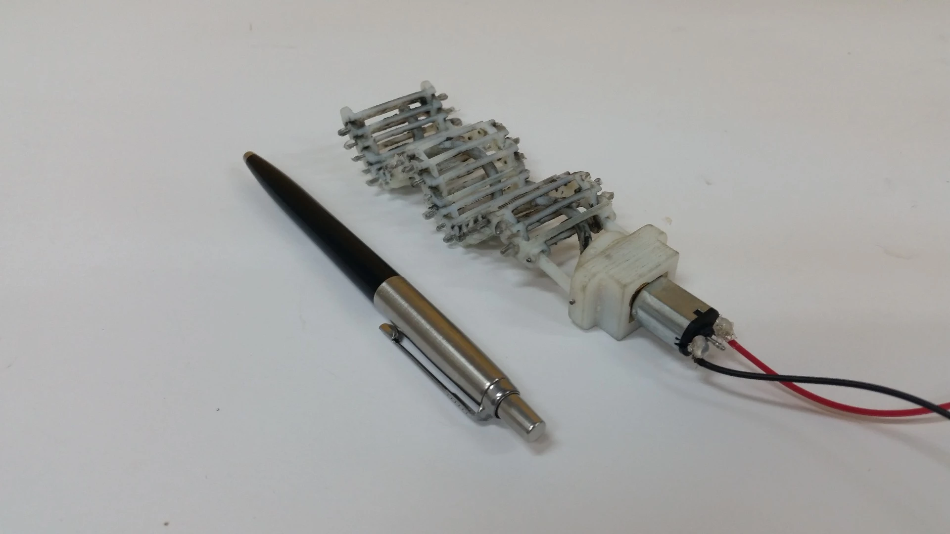 A spiral-shaped rod is fed though linked 3D-printed slats running down the body