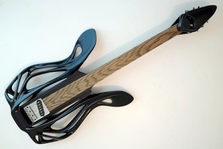 The 3D-printed Hybrid Slide Guitar's body is bolted onto a fretless wooden neck