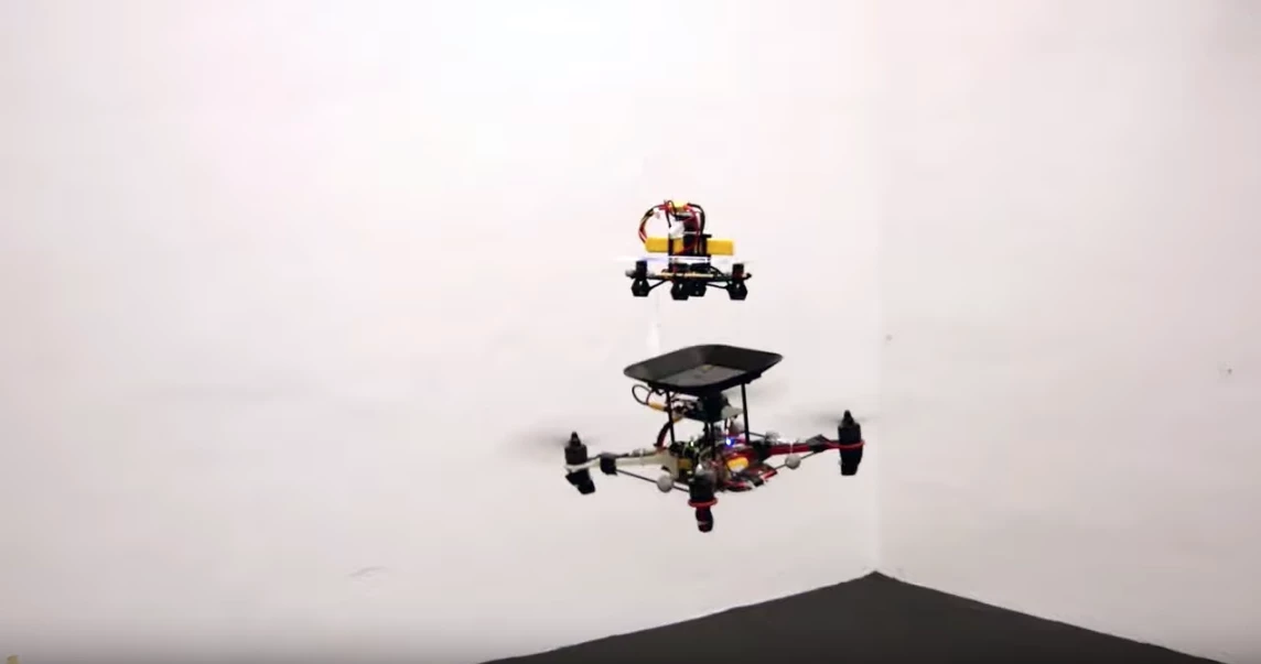 A new in-flight docking system allows a quadcopter's batteries to be topped up by a smaller drone