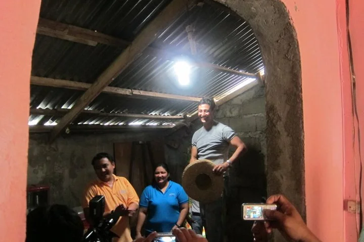 Illac Diaz (right) in a home equipped with one of his Solar Bottle Bulbs(Photo: Isang Litrong Liwanag)