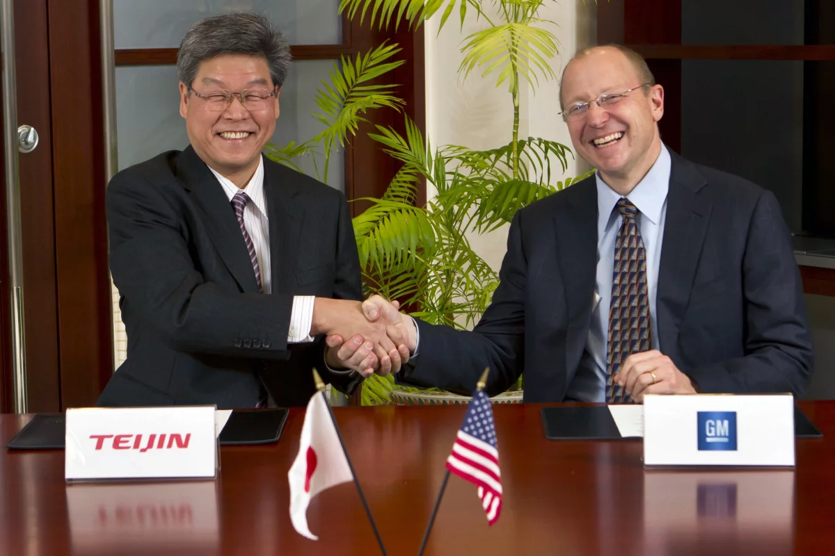 Teijin Senior Managing Director Norio Kamei (left) and GM Vice Chairman Steve Girsky shake hands after signing the carbon fiber deal (Photo by Jeffrey Sauger for General Motors)