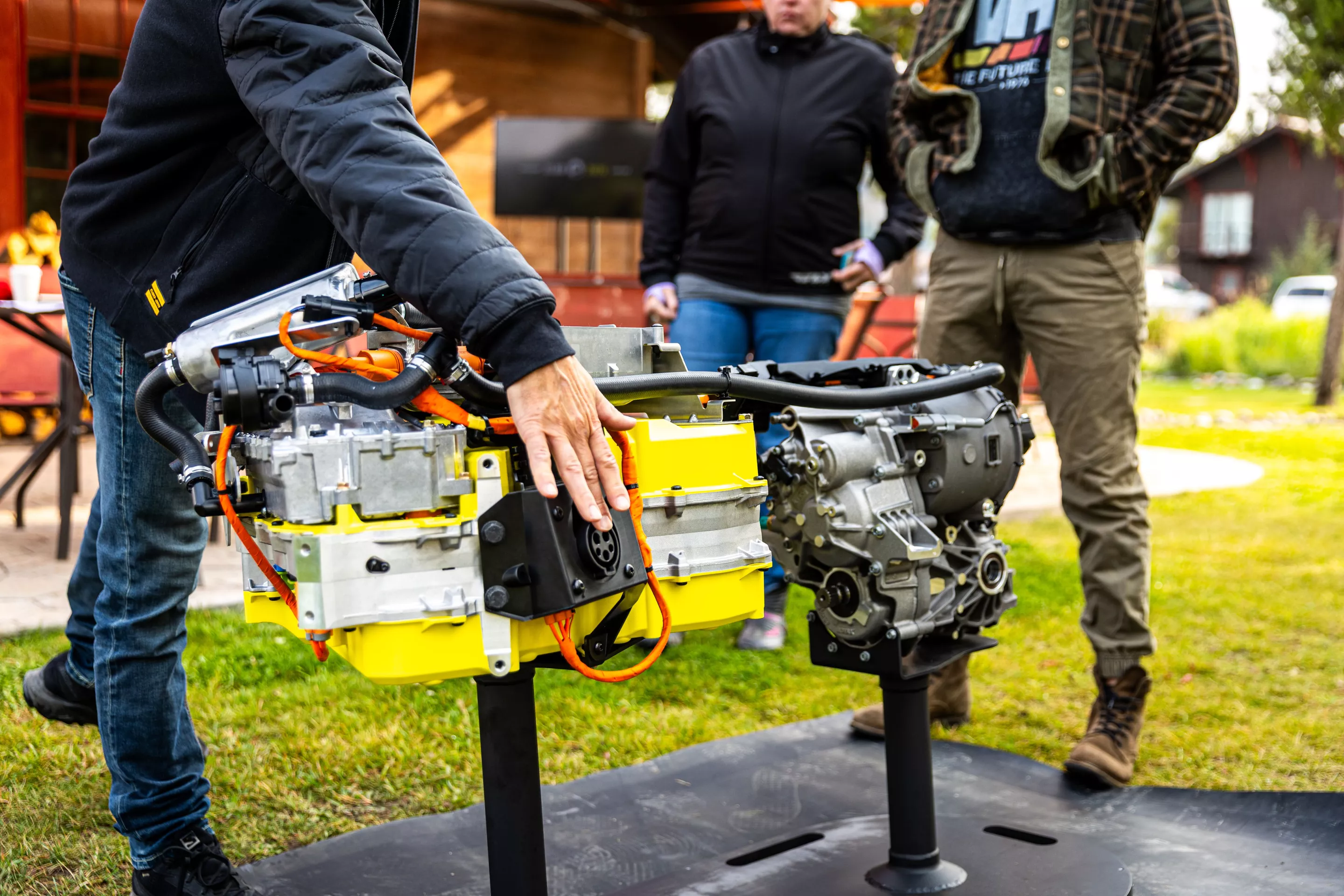 A Can-Am engineer points out the charge port on this display of the Rotax e-Power running the Outlander Electric