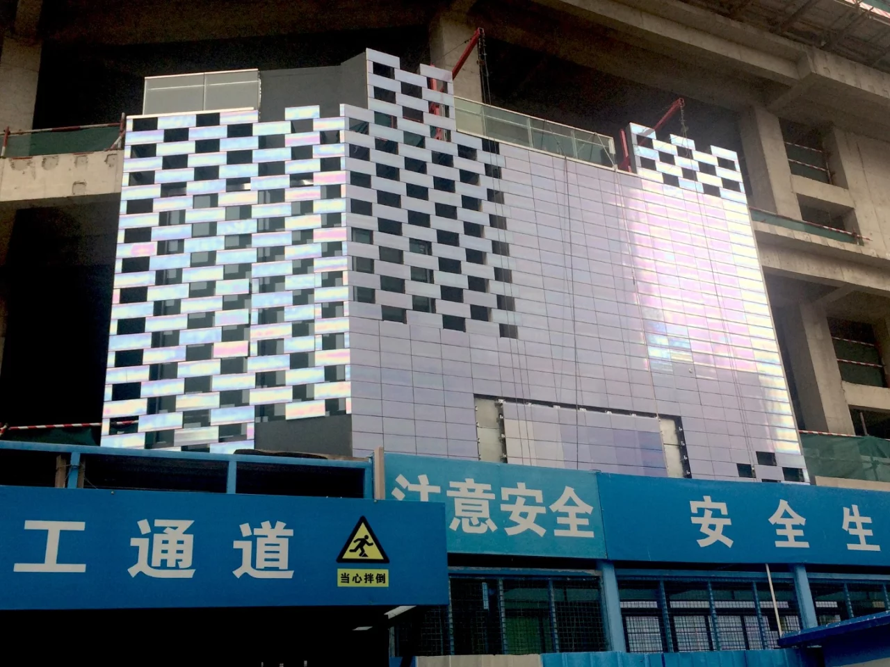 The exterior is dominated by a facade that features hand-glazed pearlescent ceramic tiles