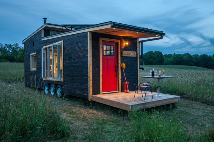 The Greenmoxie Tiny House has a drawbridge deck, which allows the tiny house to remain a reasonable length for towing but then extend when stationary to offer a generous outdoor deck area