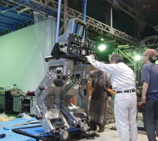 Workers stabilize Hajime Sakamoto's 4 meter tall robot during construction