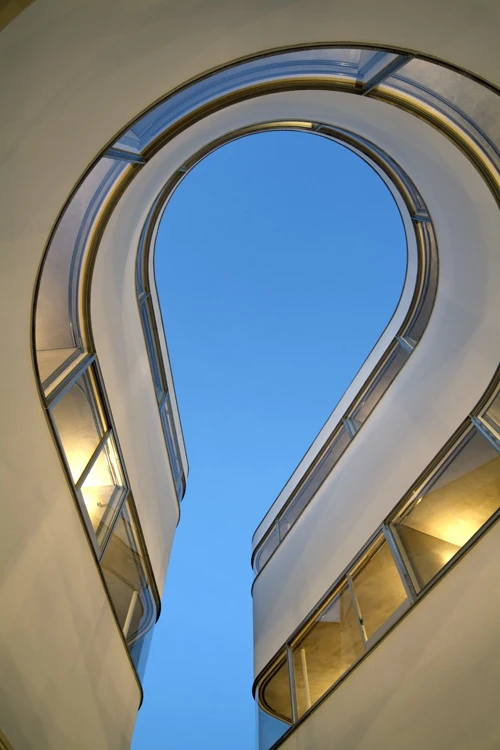 The C-shaped block, named NE apartments, envelops a central courtyard, optimally shaped for the greatest apartment volume while providing a sufficient turning circle for motorbikes