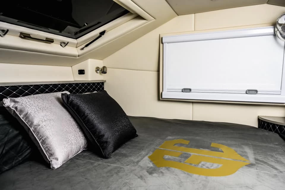 The Goliath G-47 interior includes a stargazing hatch, stainless steel reading lights, manufactured leather trim and a fridge drawer hiding away under the bed