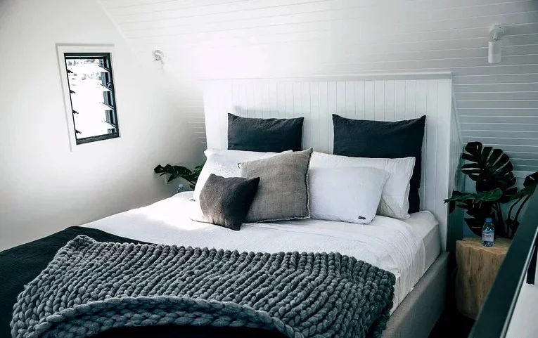 An elevated master loft bedroom offers comfortable sleeping quarters for two adults